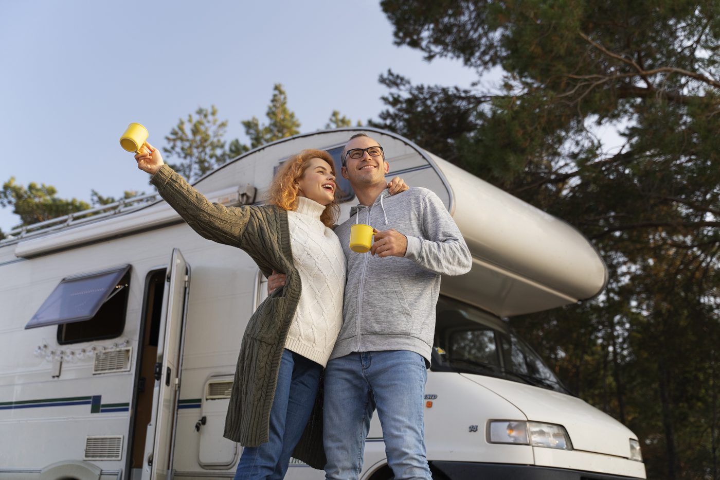 Jong stel geniet van koffie bij hun camper