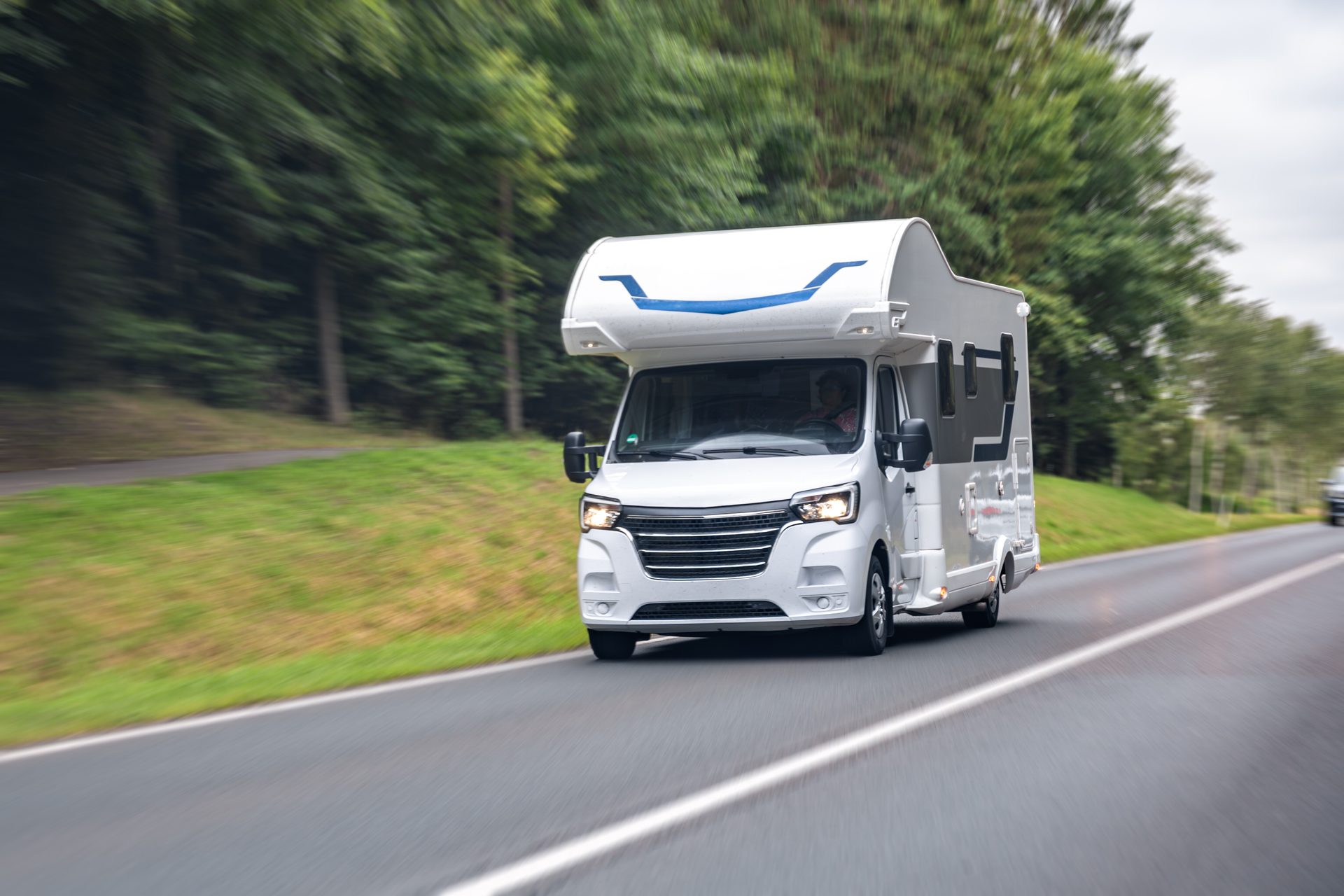 Camper onderweg onder een heldere blauwe lucht