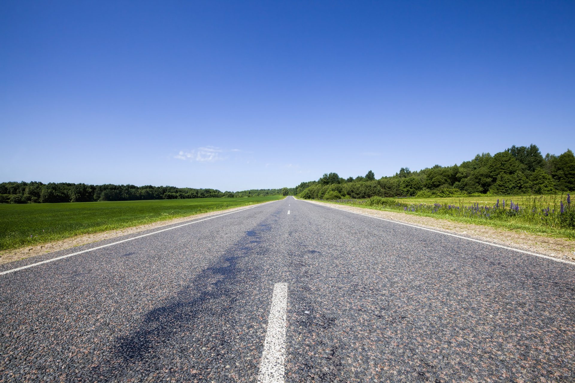 Open weg onder een strakblauwe lucht